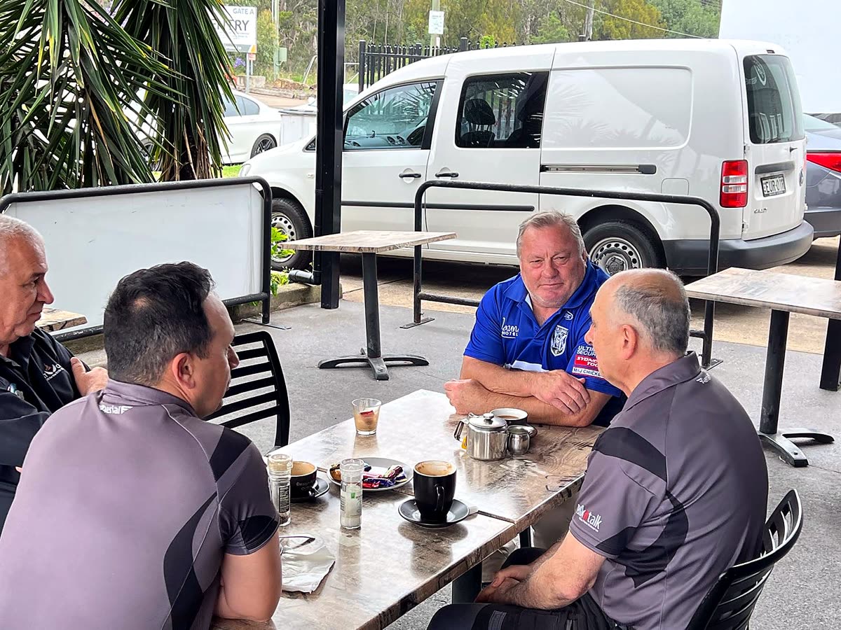 Customers at an outdoor table with coffee and the Euro Cafe van behind