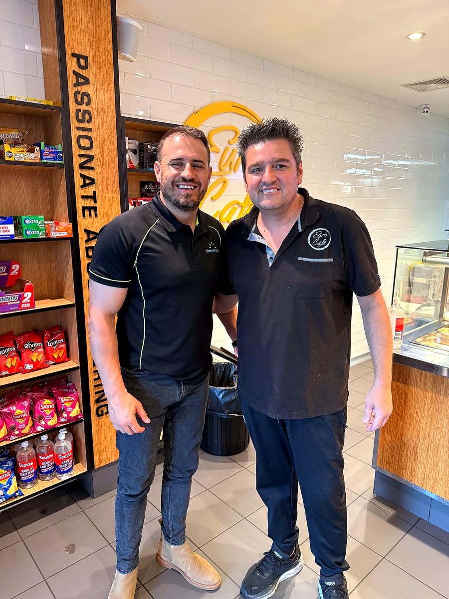 Richard with a customer beside the Passionate About Catering sign