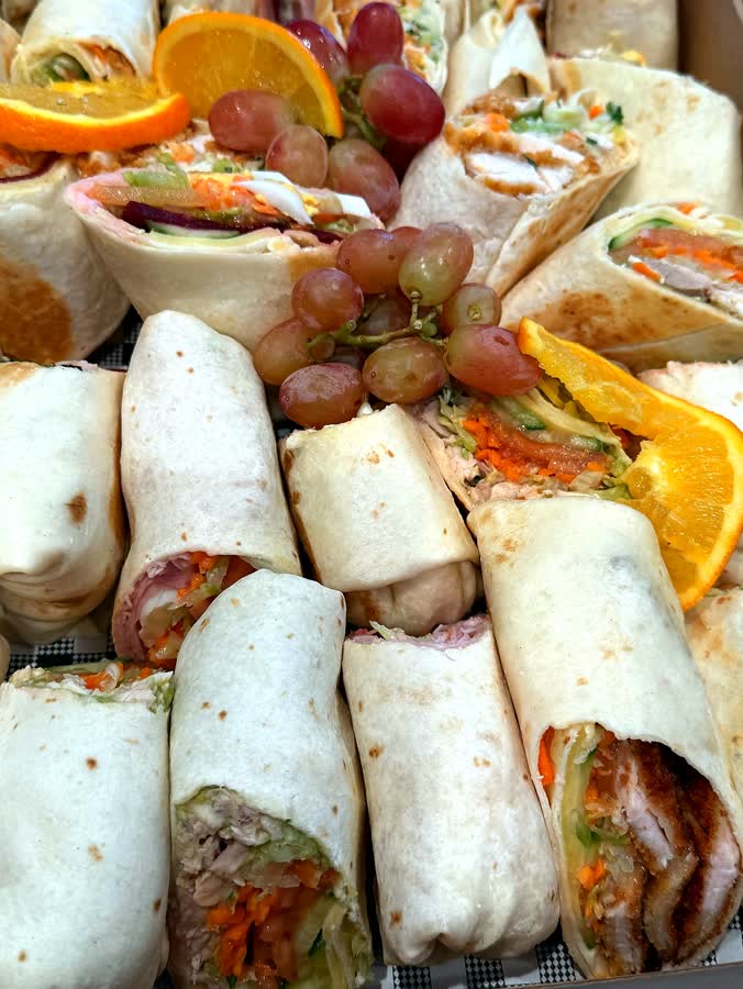 Wrap and sandwich catering platter with grapes and orange