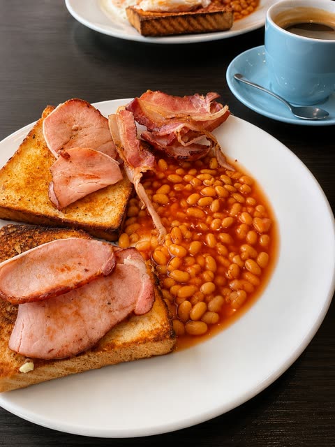 Bacon, beans and toast breakfast with a coffee