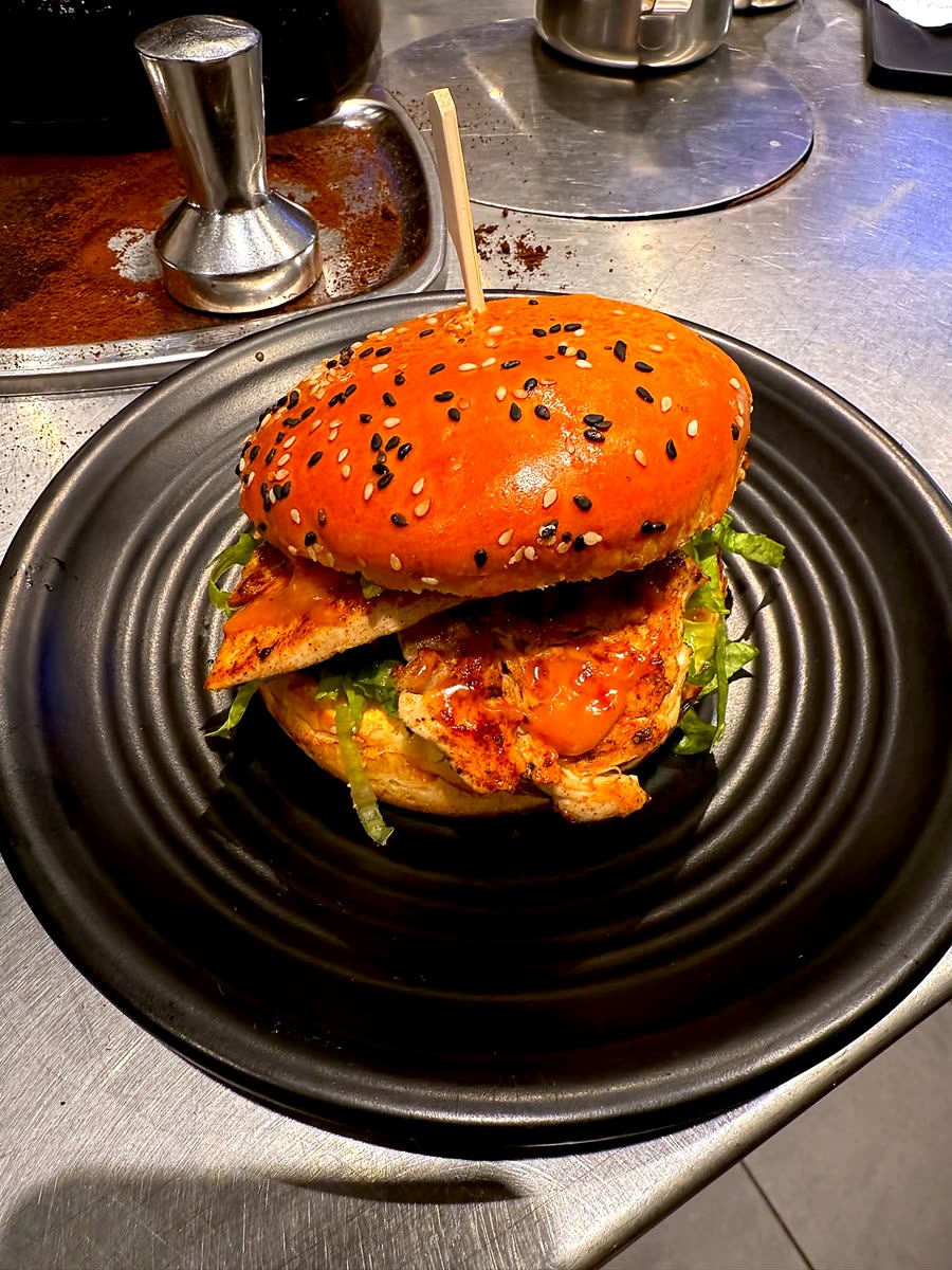 Grilled chicken burger with lettuce on a black plate