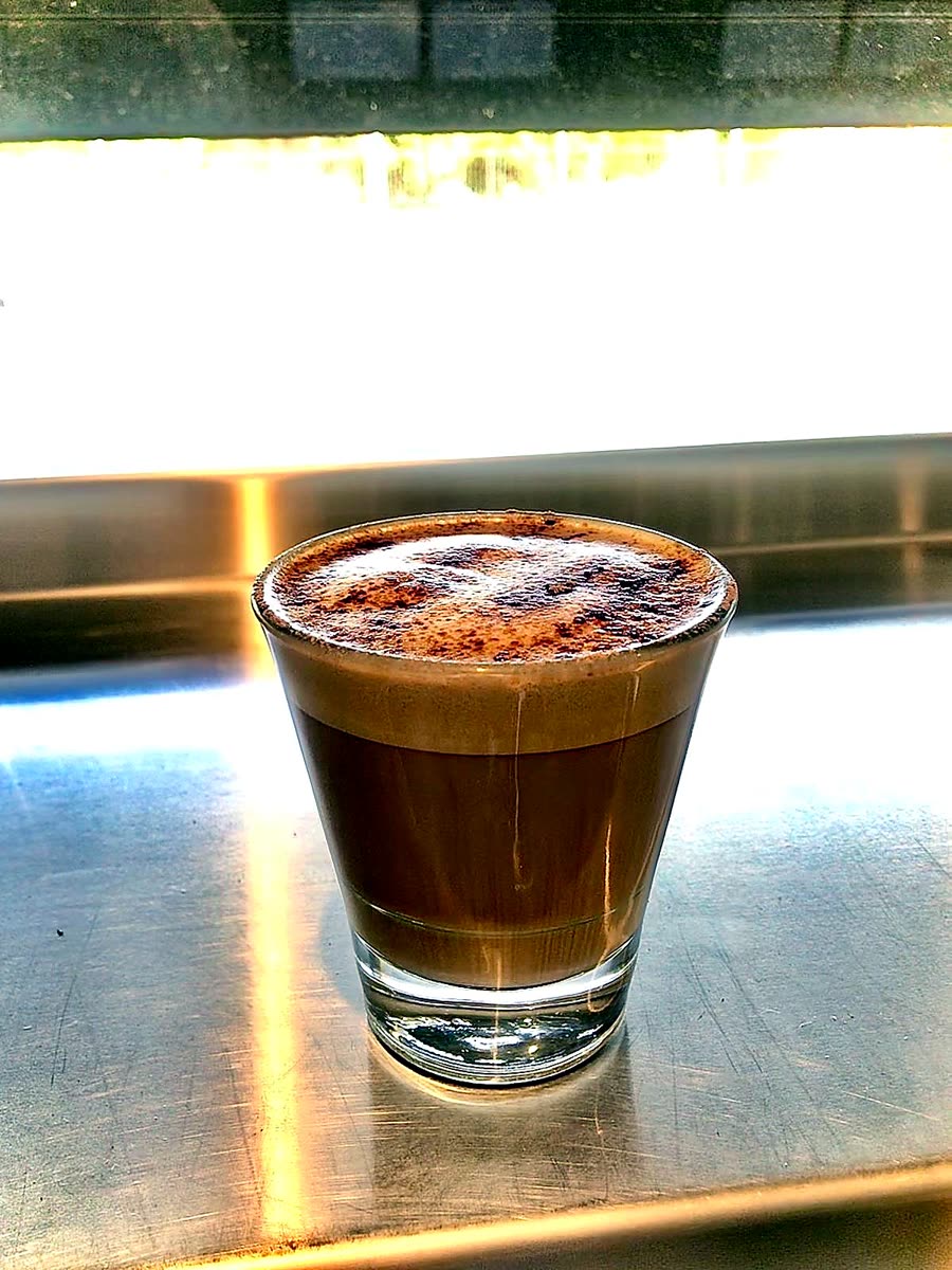 Piccolo coffee in a glass on the stainless counter